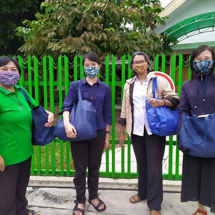 FCJ sisters in Yogyakarta Indonesia delivering gifts to neighbours for Idul Fitri