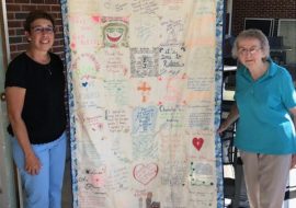 Sr Imelda receives the keeping quilt offered by St Philomena school community